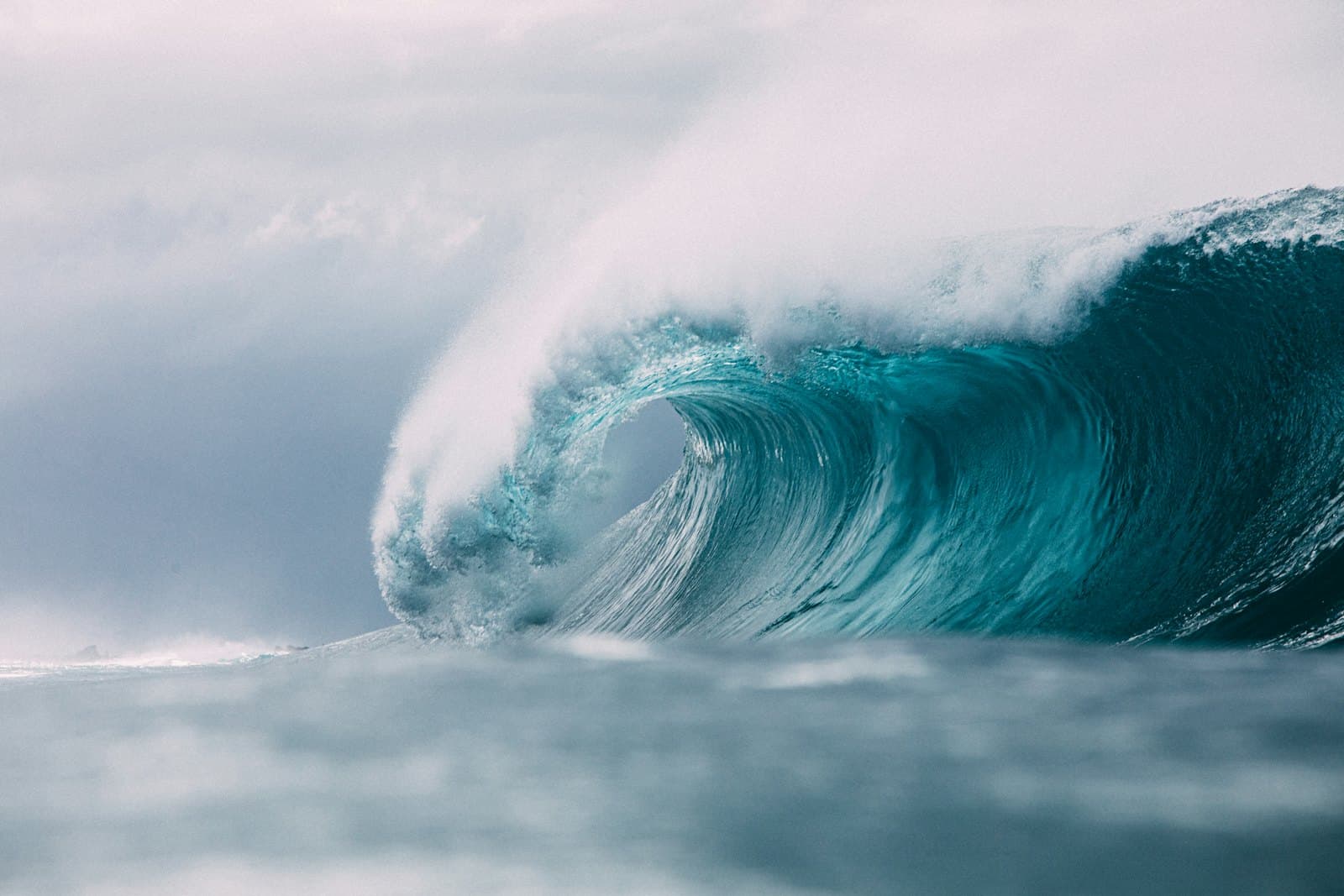 Surfer dropping into a dark ocean wave